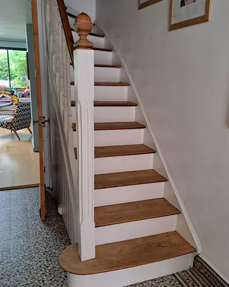 Peinture d'escalier avec contremarches blanches et balustrade peinte en laque mate sur sol terrazzo.