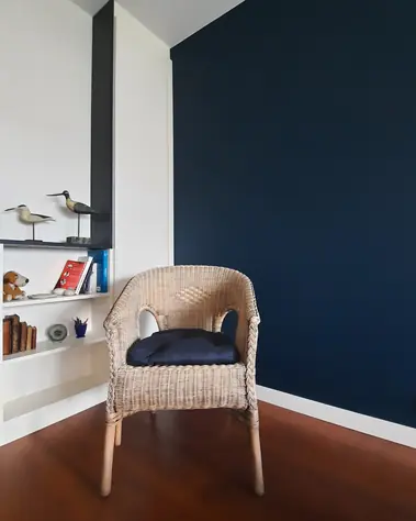 Peinture murale bleu marine et blanc avec plinthes blanches et sol en parquet