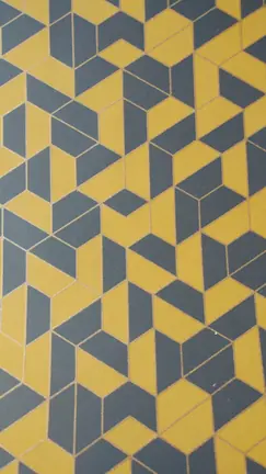 Papier peint mural motif géométrique en cubes jaunes et gris bleu aux contours dorés.
