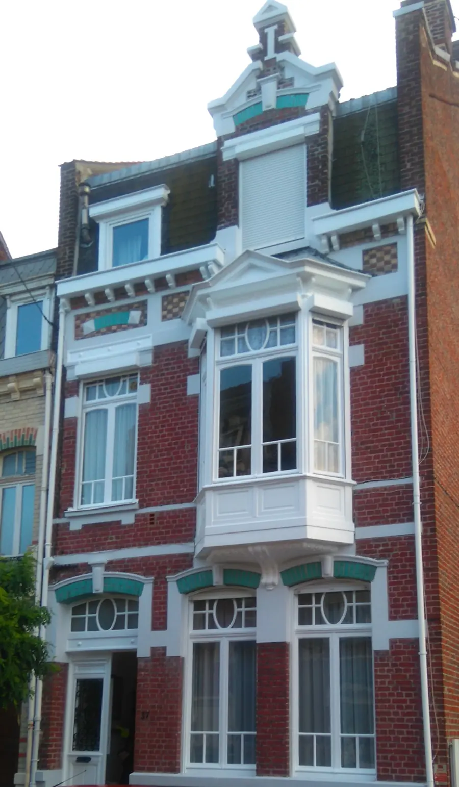Façade maison brique avec peinture extérieure blanche sur les menuiseries et moulures.
