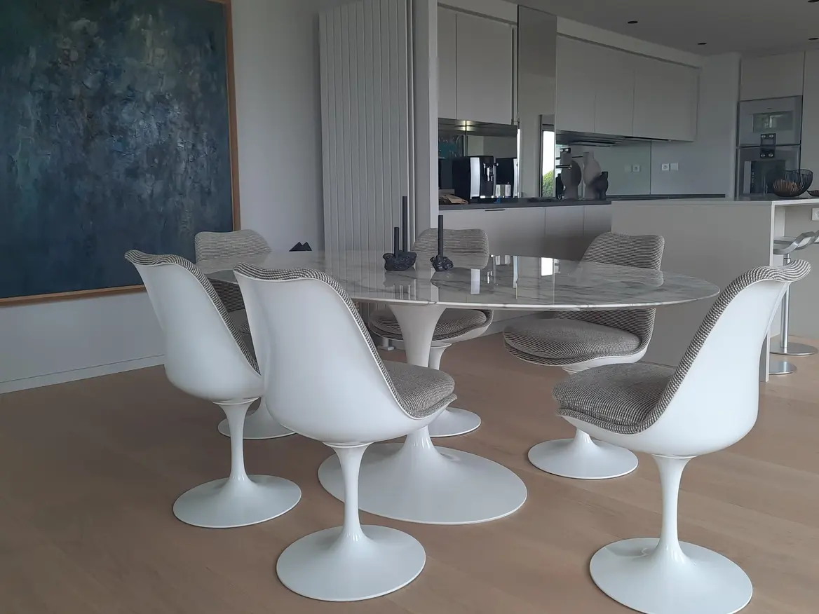 Salle à manger avec peinture intérieure blanche et sol stratifié bois clair.